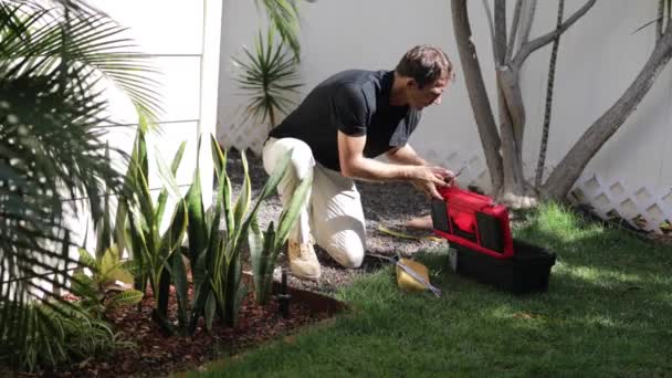 管道工把喷头固定在后院 专业的高加索花园系统安装人员安装草场洒水器 调整草坪洒水器 — 图库视频影像