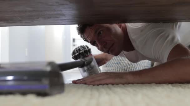 Молодий Чоловік Прибирає Підлогу Під Ліжком Лежить Підлозі Використовуючи Пилосос — стокове відео