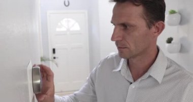 Adam evdeki akıllı termostat aletini ayarlıyor. AC sistemi