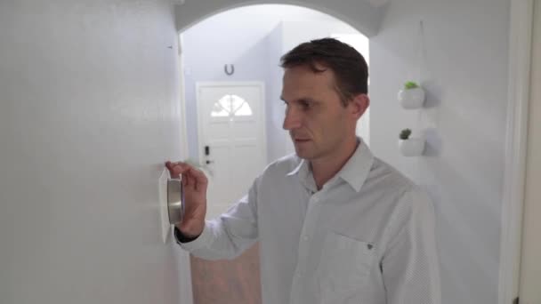 家でスマートサーモスタットガジェットを調整する男 交流システム — ストック動画