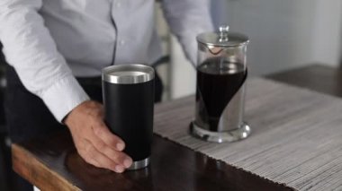 Fransız presi ile kahve siparişi veren bir adam. Kafkasyalı bir adam rahat bir evde mutfakta kahve bardağına kahve dolduruyor. Yavaş Hareket.