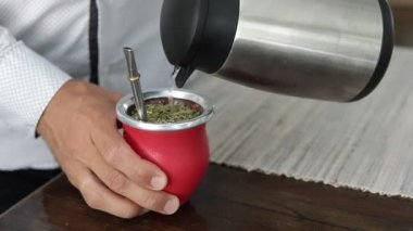 Yena Mate çayı yapan adam. Geleneksel çiftleşme bardağına sıcak su dök. Tencere dibin kara seninki benden kara, seninki benden kara. Tencere dibin kara, seninki benden kara. Yavaş Hareket.