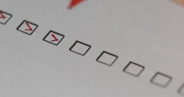 Kalemle İşaretli Kişi İşaretleri Yapılacaklar Listesini dolduruyor. Kırmızı kalemle yapılacaklar listesini işaretleyen biri. Kontrol listesindeki tüm kutuları işaretle, yakın plan, 4k