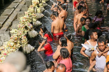 BALI, İNDONEZYA - 16 Nisan 2016: Kutsal kaynak suyu. Tirta Boş Tapınağı 'nda dua eden insanlar. Bali, Endonezya.