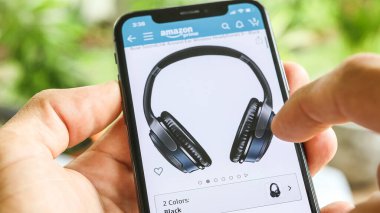 NEW YORK CITY, NY - 1 Aralık 2019: Mobil Akıllı iPhone ile Amazon uygulamasında kulaklık arayan adam