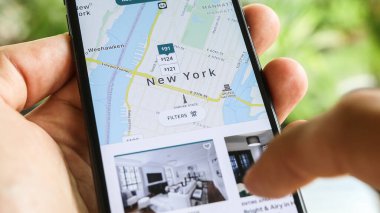NEW YORK CITY, NY - 1 Aralık 2019: Airbnb uygulamasını kullanarak New York 'ta ev kiralamaya çalışan kadın