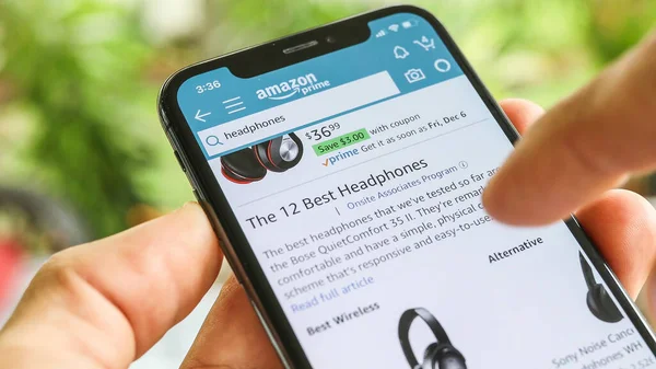 NEW YORK CITY, NY - 1 Aralık 2019: Mobil Akıllı iPhone ile Amazon uygulamasında kulaklık arayan adam