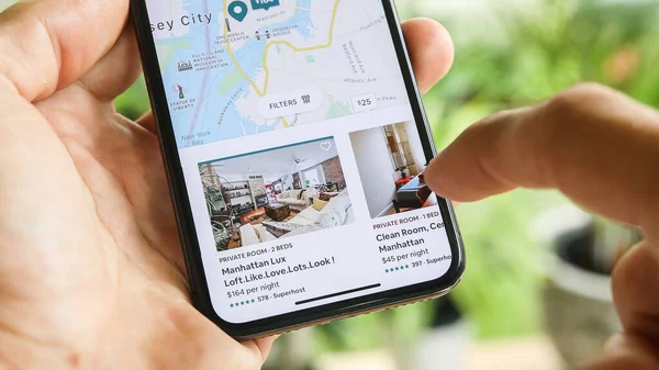 NEW YORK CITY, NY - 1 Aralık 2019: Airbnb uygulamasını kullanarak New York 'ta ev kiralamaya çalışan kadın