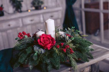 Sepet çam dalları, bir mum ve gül ahşap bir masa üzerinde