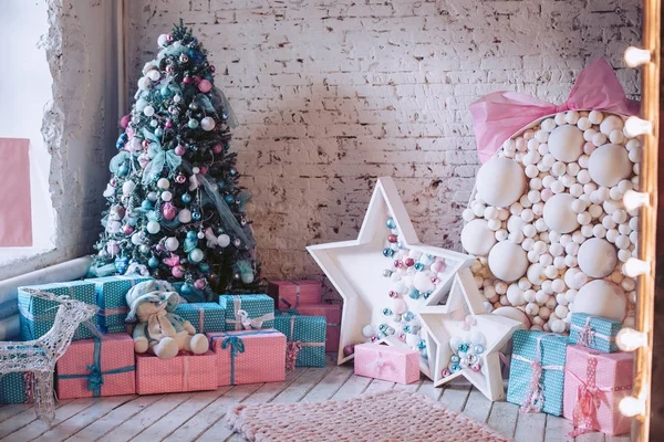 Intérieur du Nouvel An. Arbre de Noël, ornements décoratifs, cadeaux et jouets sous lui. Luxueux, lumineux, beaux intérieurs de la maison. Luxueux, lumineux, beaux intérieurs de la maison dans des couleurs claires — Photo