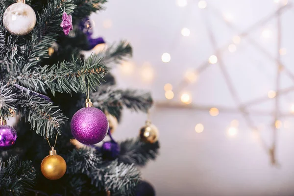 Χριστουγεννιάτικο δέντρο με πολύχρωμα παιχνίδια και μια γιρλάντα με σχήμα αστεριού — Φωτογραφία Αρχείου