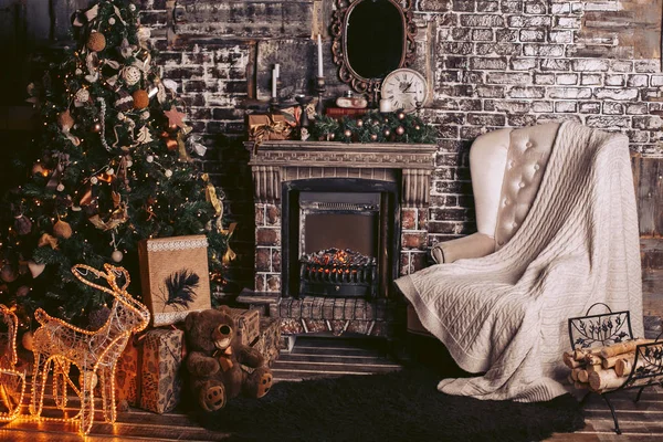 Intérieur du Nouvel An avec une cheminée chaude, un sapin de Noël et des éléments décoratifs aux couleurs sombres — Photo