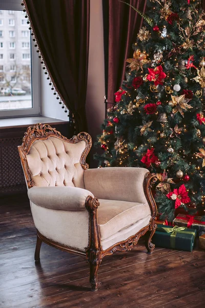 Chaise luxueuse à l'intérieur. Fête du Nouvel An. Arbre de Noël décoré de jouets et d'une guirlande — Photo