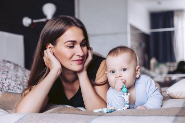Bir yatakta yatarken çocuk güzel annem bakar