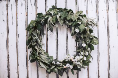 Çelenk bitki kurullarında yapılan bir beyaz tahta duvar ve güller