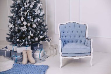 Yeni yılda bir mavi modern şık sandalye iç. Süslemeleri ile Noel ağacı. Hediye paketleri