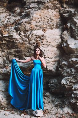 Seksi kızın yanında mavi bir elbise içinde taş bir kaya