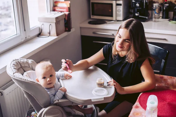 Mama z małym dzieckiem w kuchni. Źródła noworodka z th — Zdjęcie stockowe