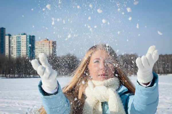 Flickan kastar snö upp i staden. Kallt väder — Stockfoto