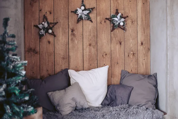 Cama con almohadas con atributos de Año Nuevo en el fondo de un panel de madera —  Fotos de Stock