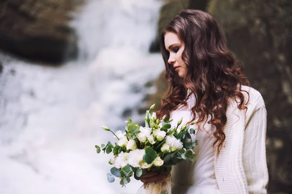 Fille sexy avec un bouquet de fleurs de mariage sur le fond d'un glacier et les montagnes — Photo