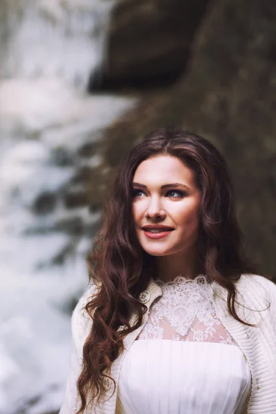 Egy mosollyal az arcán, rajta egy esküvői ruha menyasszony. Portré a gleccser háttér. — Stock Fotó