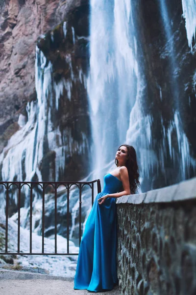 Красивая юная брюнетка в синем платье на фоне горного массива и ледника — стоковое фото