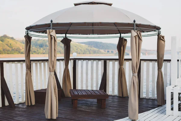 Beautiful modern marquee on the terrace of the landing stage. Natural wood. View of the river and mountains. — 스톡 사진