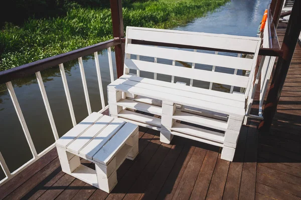 Banco caseiro com uma mesa de paletes, pintado de branco. Lugar de descanso no palco de aterragem. Madeira natural . — Fotografia de Stock