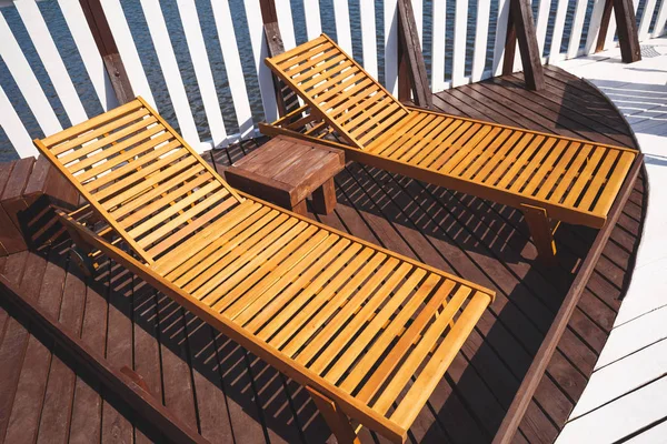 Cadeiras de plataforma de madeira no terraço do estágio de desembarque em clima ensolarado de verão . — Fotografia de Stock
