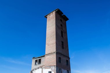 Mavi gökyüzünün arka planında terk edilmiş eski bir bina.