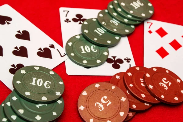 Kırmızı Arka Planda Yedi Dağınık Poker Fişleri — Stok fotoğraf