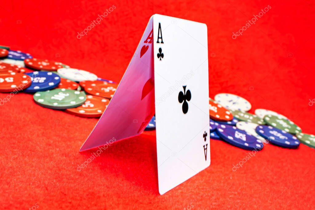 Two aces folded by a house on a red background