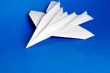 Mavi arka planda beyaz kağıt uçak