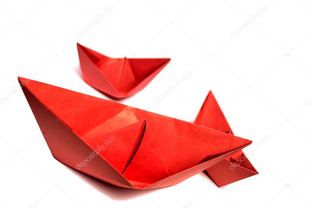 Red paper boats on a white background