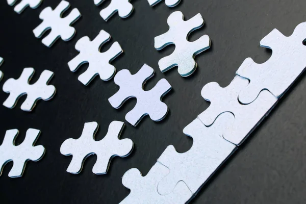 Blue puzzles on a black background close-up