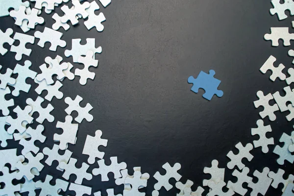 Blue puzzle surrounded by blue on a black background