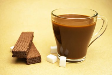 Bir fincan kakao, rafine şeker ve çikolatalı waffle..