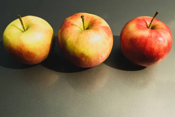 Три Яблока Сером Фоне Подряд — стоковое фото