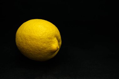 Siyah arka planda taze, sulu, sarı, kendini beğenmiş limon.