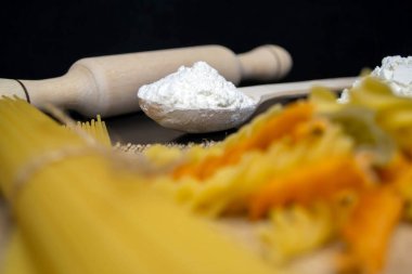 Makarna, spagetti, un, merdane, siyah arka planda tahta kaşık.