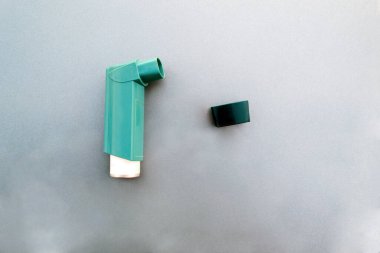 Astım spreyi, ilaç, solunum için gri arka plan.