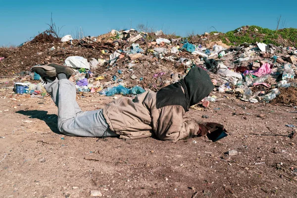 Грязная Бездомная Лежит Земле Возле Свалки Смотрит Планшет — стоковое фото