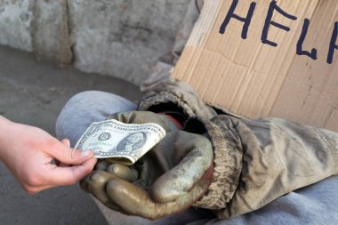 Evsiz, pis kadın gelip geçenlerden yardım istiyor.