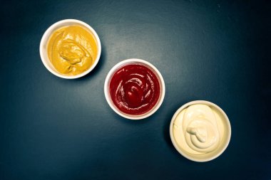 Ketçap, mayonez, siyah arka planda hardal sosu.