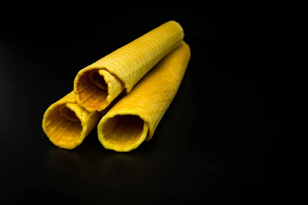 Wafer rolls with condensed milk on a black background