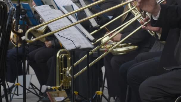 管楽器で演奏する吹奏楽部ストリートミュージシャンがトロンボーンの野外演奏で音楽を演奏音響器楽バンド — ストック動画