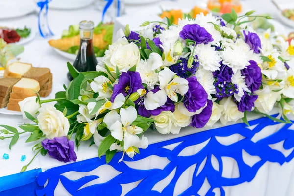 花嫁および新郎とウェディング レストランのテーブルの上に花の青と白の装飾 — ストック写真
