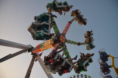 Akşamları ve akşamları lunaparktaki çocuk atlıkarıncasında. Geceleyin eğlence parkı. Lunapark, arka plan için resim.