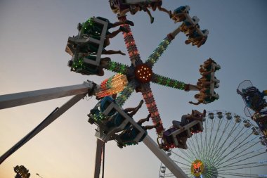 Akşamları ve akşamları lunaparktaki çocuk atlıkarıncasında. Geceleyin eğlence parkı. Lunapark, arka plan için resim.